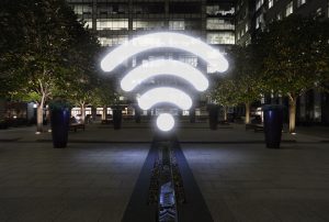 Glowing wifi icon in city street at night, London, UK