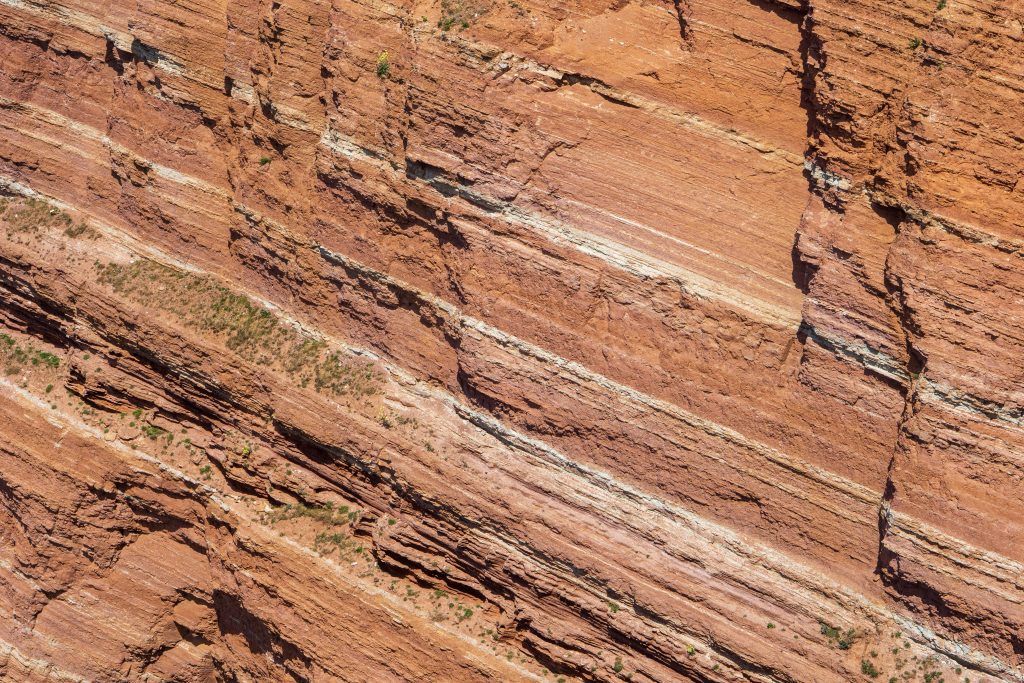 Pieskovec tvoriaci rôzne hrubé vrstvy sfarbené od železa do červena, oddelené svetlejším materiálom