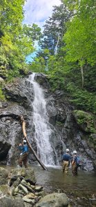 Výskumníci stoja pod vysokým vodopádom