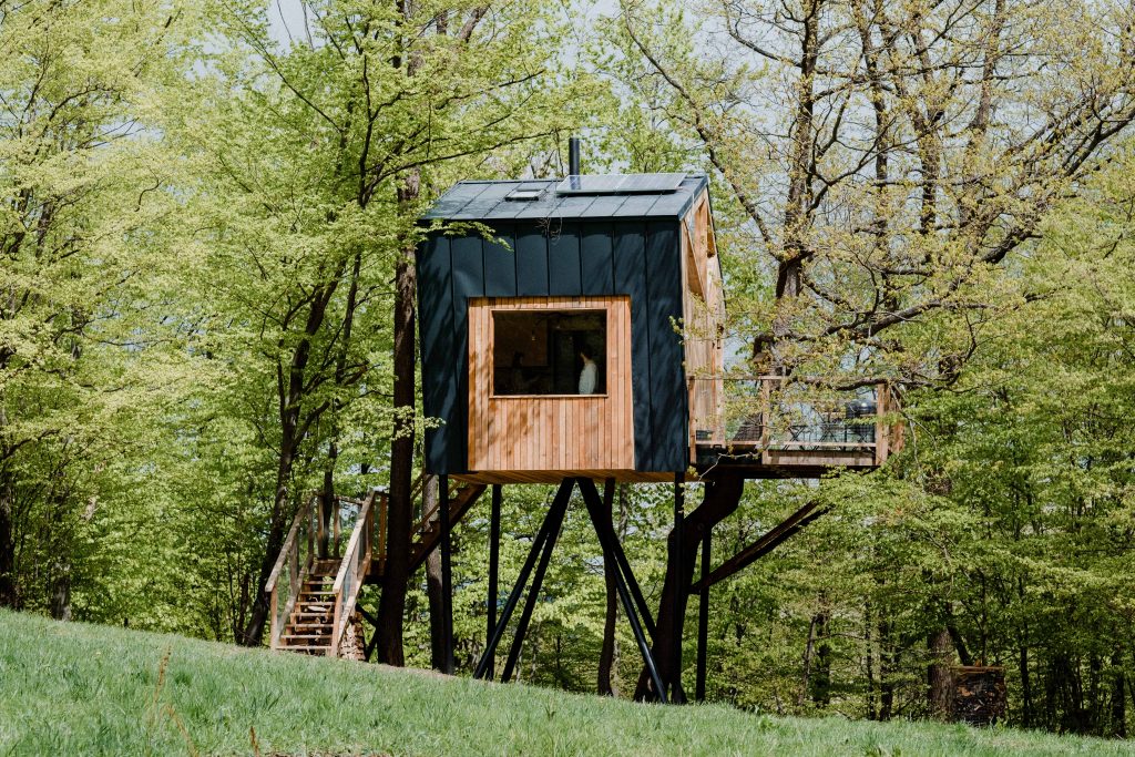 Čierny dom na strome s mohutným schodiskom a terasou