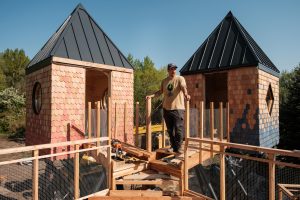 Architekt stojí uprostred stavby domu na strome