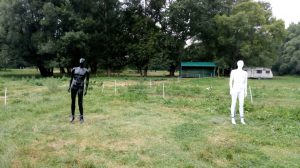 Dve figuríny na trávnatej ploche počas experimentu