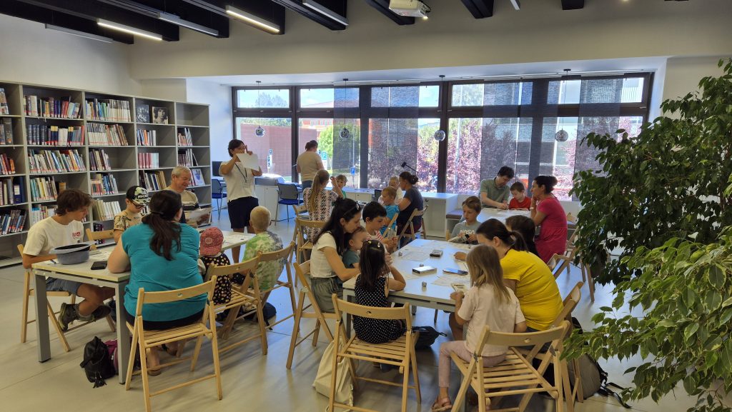 Ľudia rôznych vekových kategórií programujú roboty v knižnici