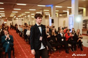 Mladý muž kráča na pódium pri udeľovaní ocenení