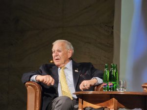 Starší výskumník v obleku počas diskusie zapálene vysvetľuje okolnosti svojho nálezu