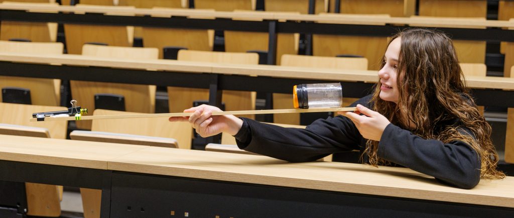 Študentka hovoriaca do rezonančnej nádoby