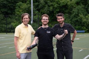 Trojica vedcov civilnom oblečení drží nový deravý padák