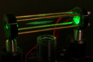 Zrnká múky v hranatej sklenenej trubici podsvietené zeleným svetlom