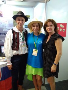 Muž v kroji a klobúku pózuje s dvoma ženami