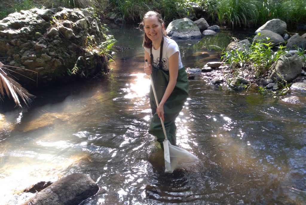 Výskumníčka stojí pri výskume uprostred rieky