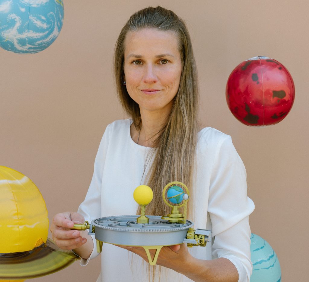 Portrét Ľubomíry Hujsovej s modelom sústavy Slnko – Zem