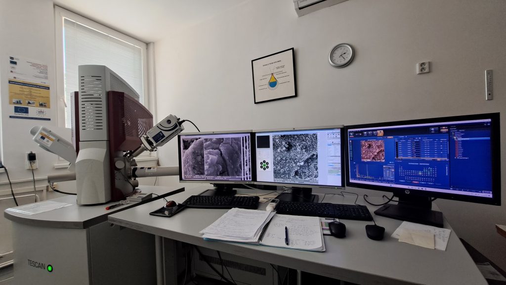 Mikroskop a tri obrazovky v laboratóriu