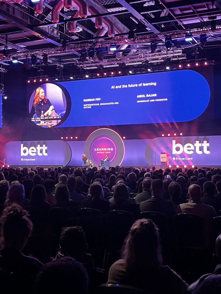 Záber na pódium s obrazovkou počas konferencie