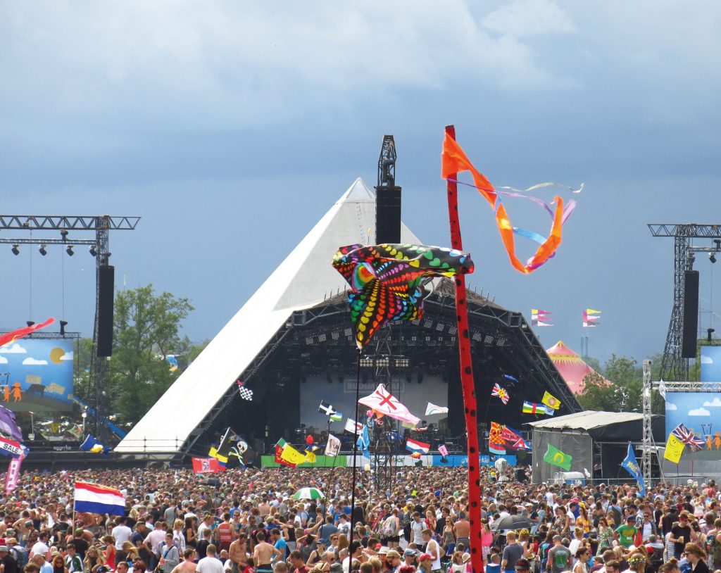 Festivalový stan s pódium a ľudia, ktorí sa zabávajú