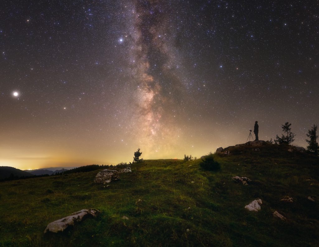 Mliečna cesta a hviezdy na letnej oblohe spolu s fotografom