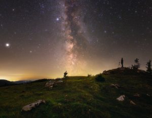 Mliečna cesta a hviezdy na letnej oblohe spolu s fotografom.
