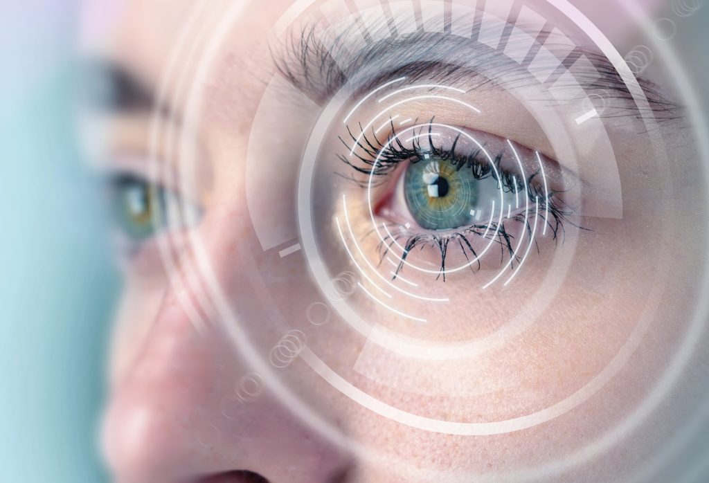 Otvorené oko ženy v kombinácii so symbolmi predstavujúcimi fotometriu alebo deepfake