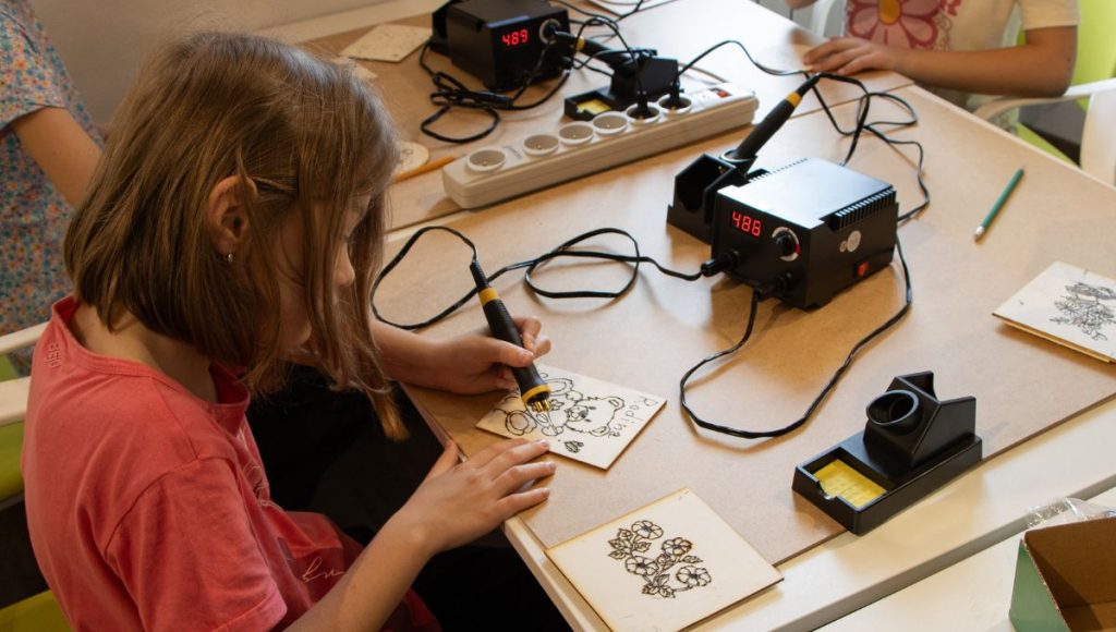 Dievča venujúce sa pyrografii