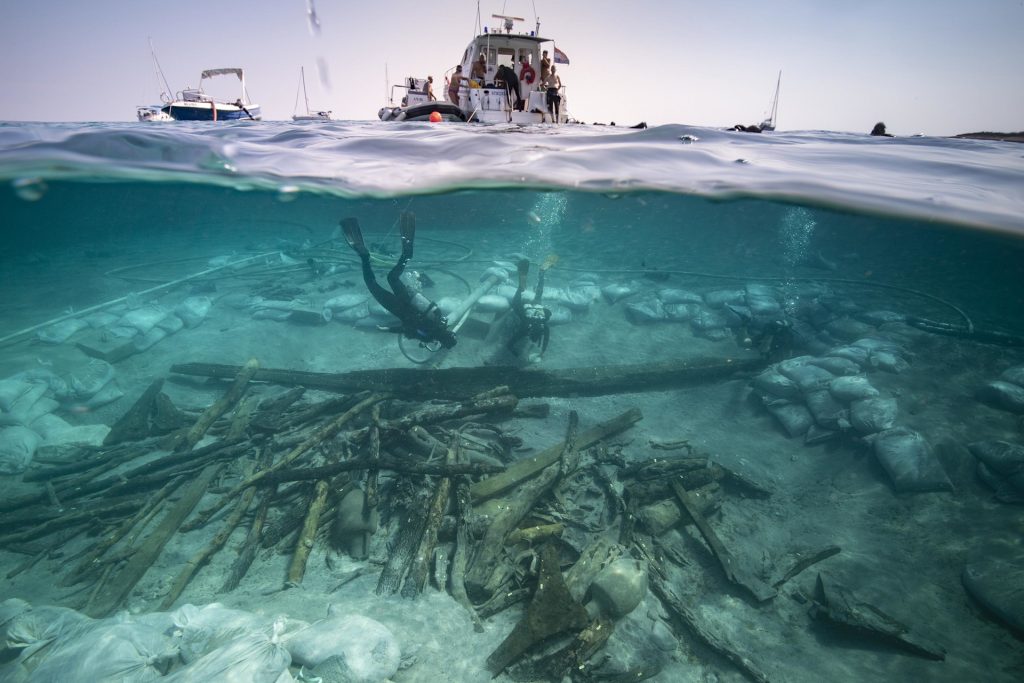 Potápač prehľadáva vrak lode pod vodnou hladinou